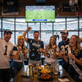 Group of friends celebrating at a sports event on a bachelor bachelorette sports trip